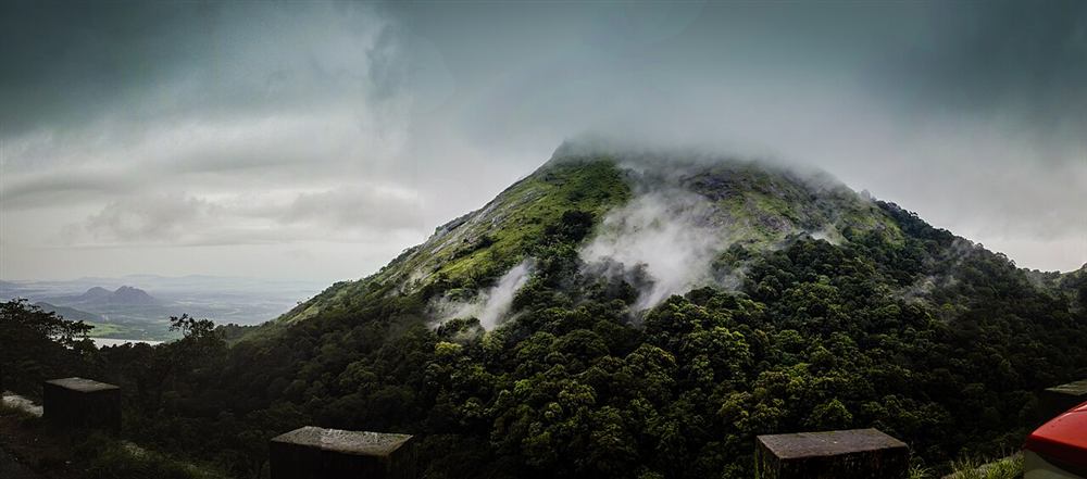 Mist rolling over the forested Nelliyampathy hills