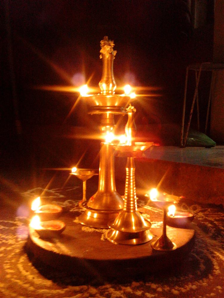 A lit brass oil lamp glowing in the dark